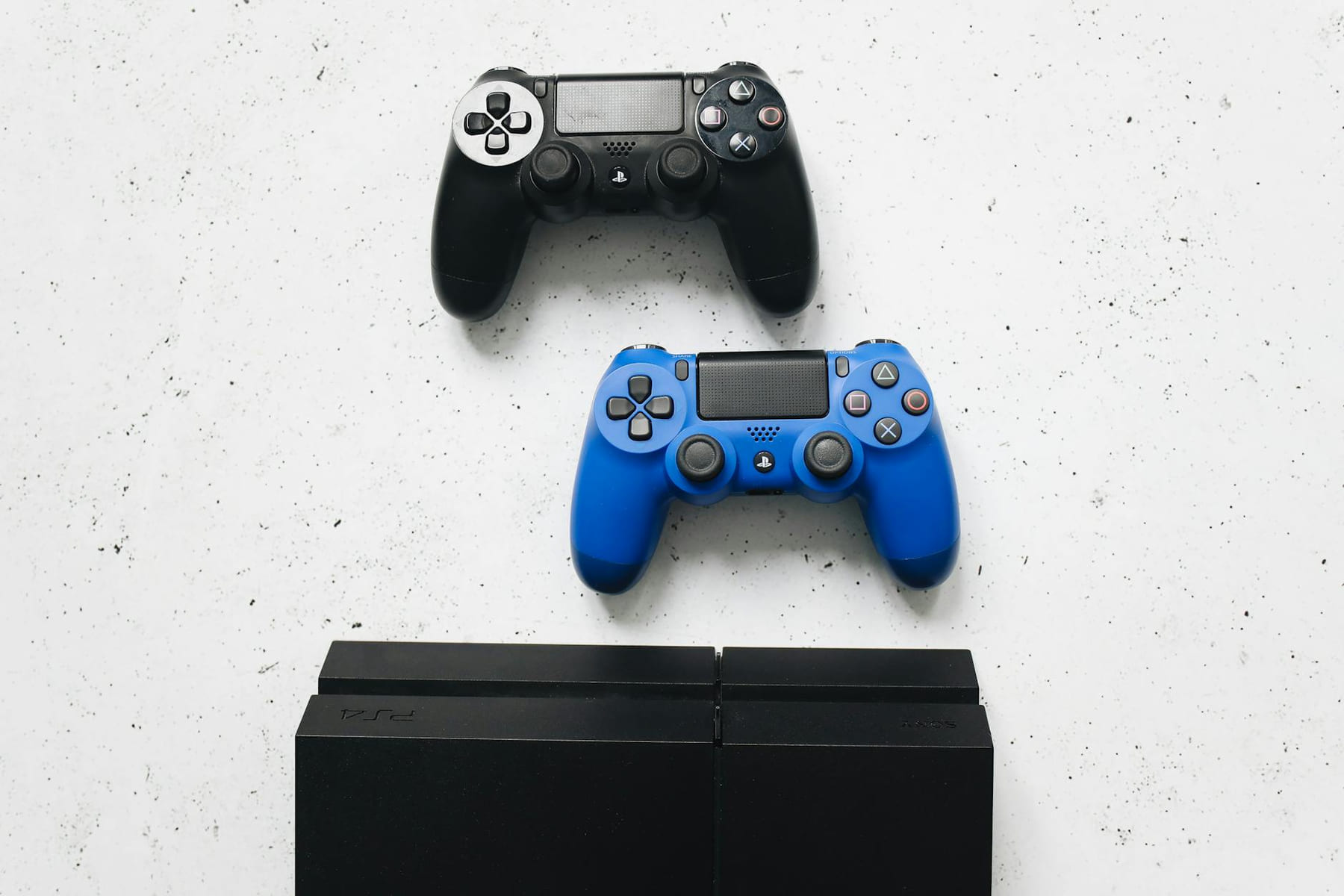 Two game controllers placed on a white surface above a gaming console. on The Loading Screen