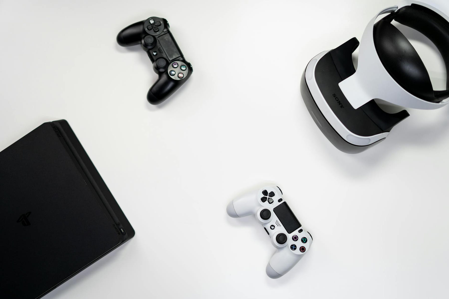 Flat lay of gaming console, controllers, and VR headset on a white background. on The Loading Screen