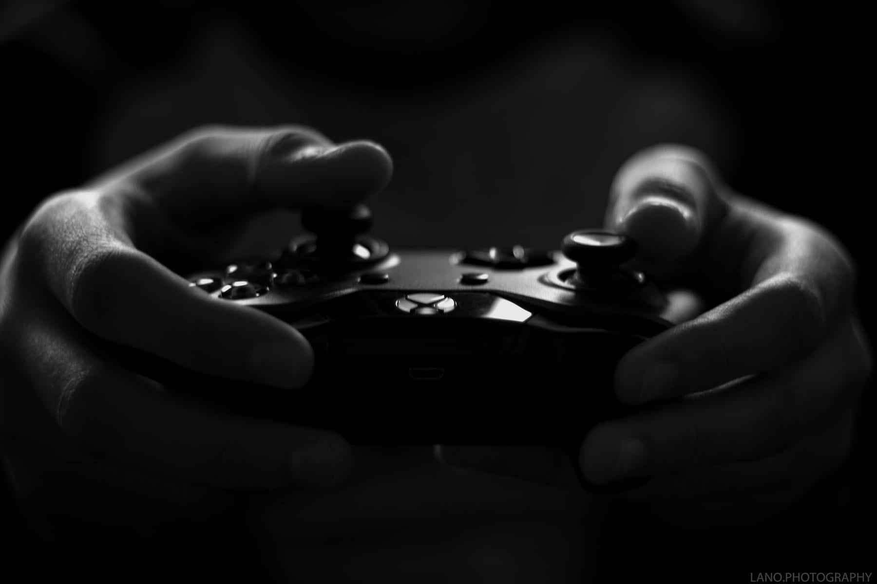 Close-up of hands holding a game controller in a monochrome setting, capturing the essence of gaming. on The Loading Screen