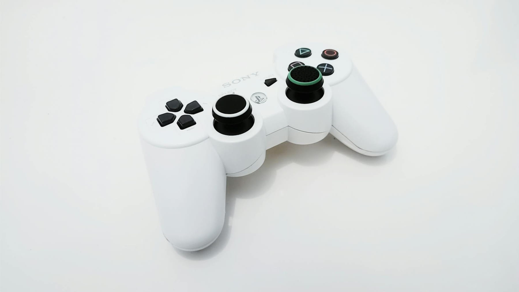 Close-up of a white gaming controller, ideal for PlayStation console enthusiasts. on The Loading Screen