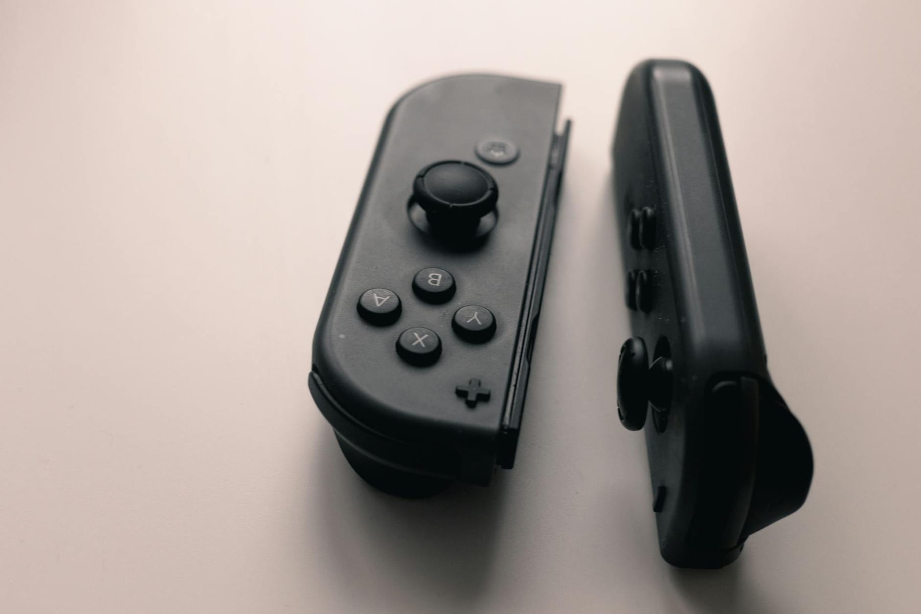 A close-up image of two Nintendo Switch Joy-Con controllers on a neutral background. on The Loading Screen