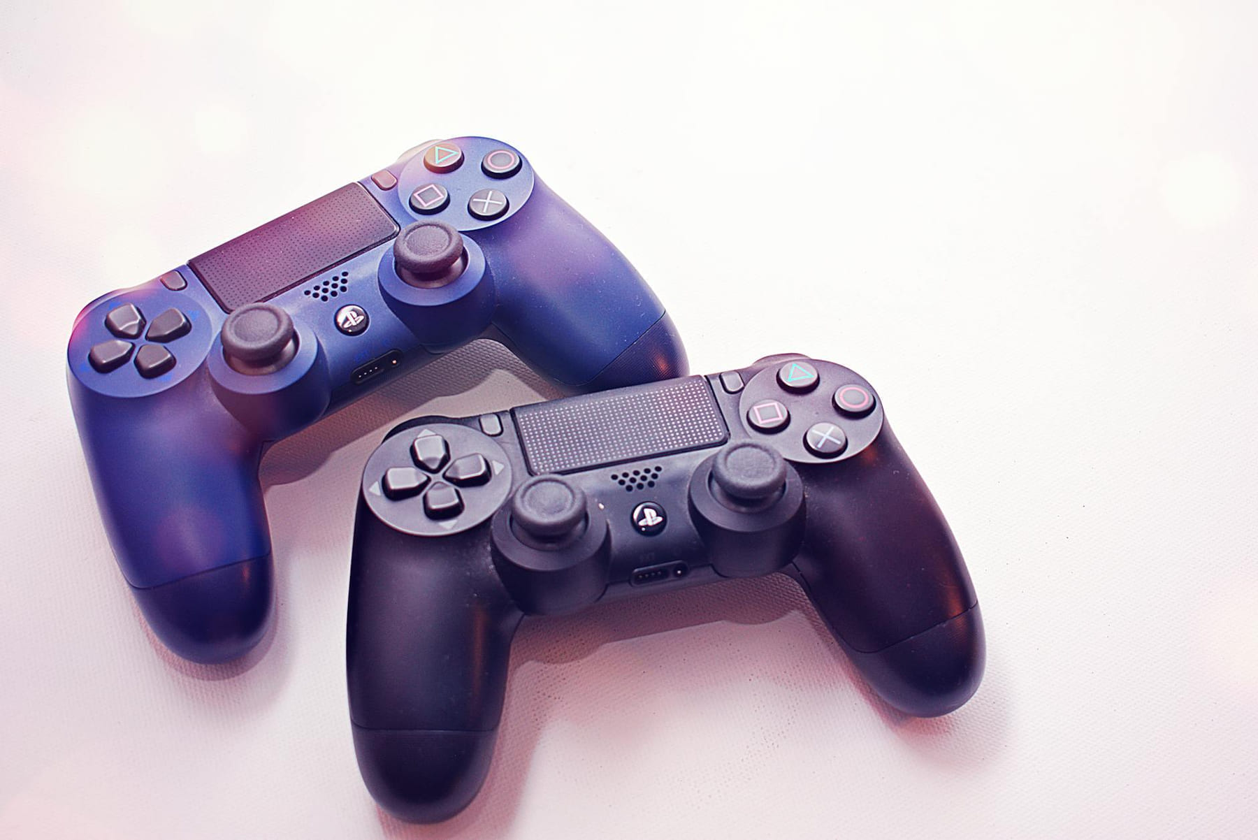 Close-up of two PlayStation controllers on a white surface, perfect for gaming themes. on The Loading Screen