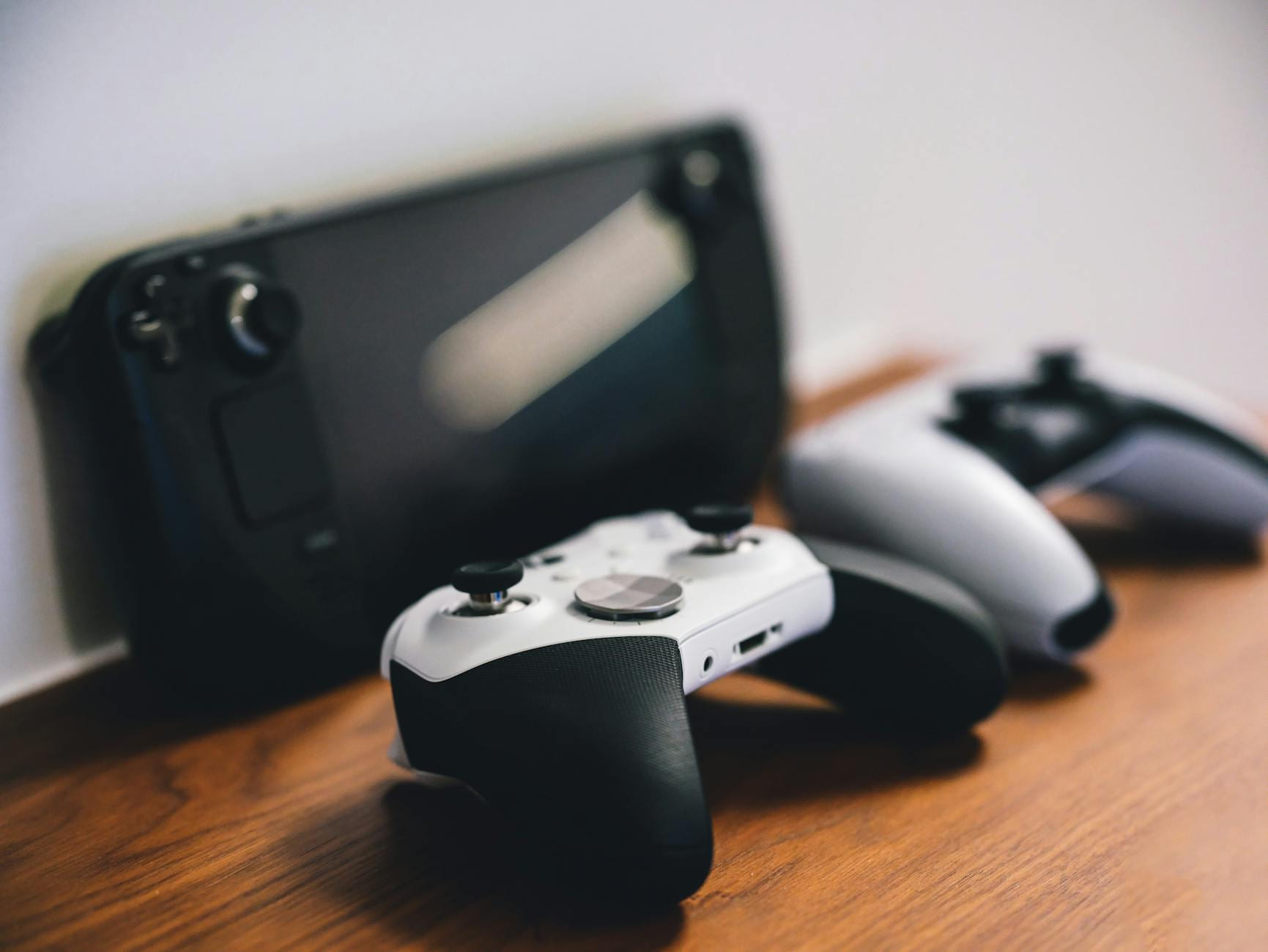 Stylish setup of gaming controllers and console on wooden surface. on The Loading Screen